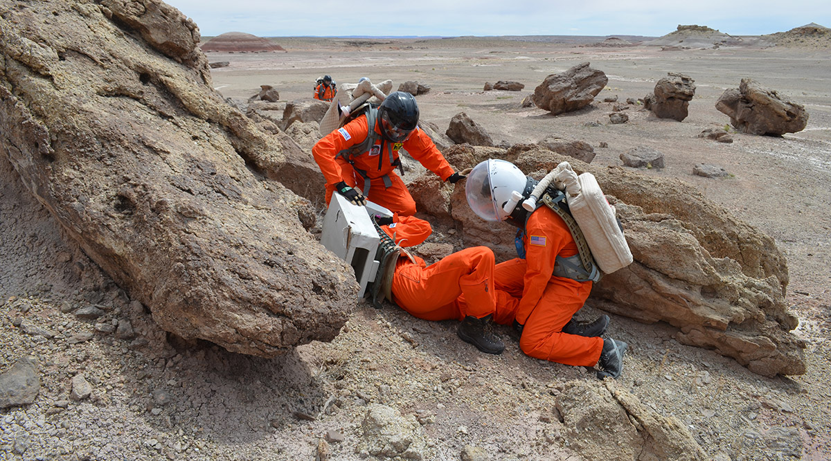 people in spacesuits on beach