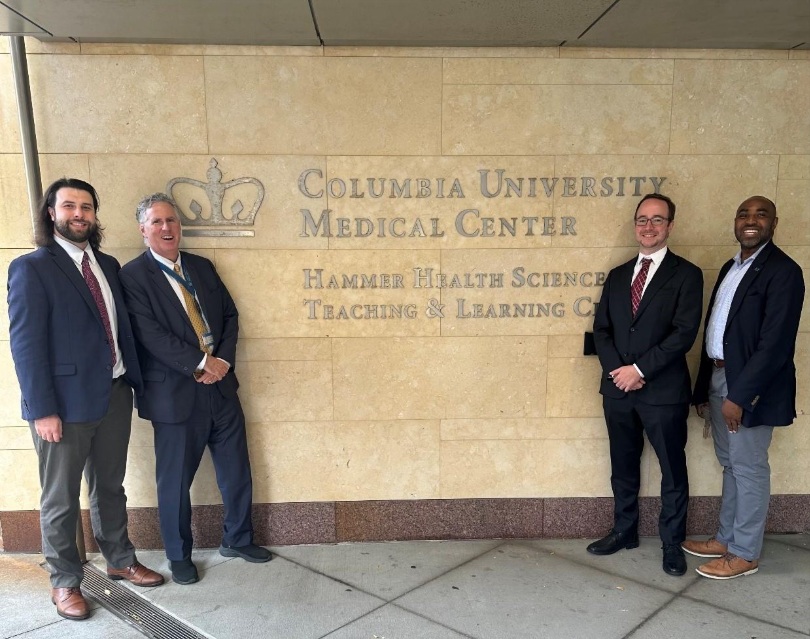 men stand in front of Columbia Univeristy Medical Center sign