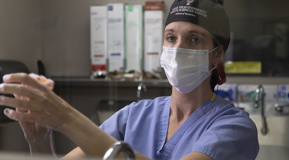 Brittany Bankhead-Kendall, MD, now a trauma surgeon at Texas Tech University Health Sciences Center, saw a flood of deaths during the pandemic and has suffered symptoms of PTSD. She is shown here scrubbing in for surgery.