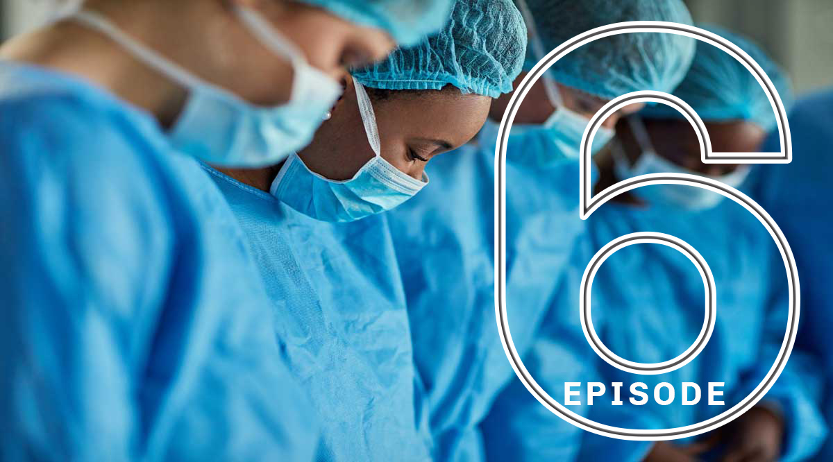 Diverse physicians wearing masks and medical caps and gowns in the operation room