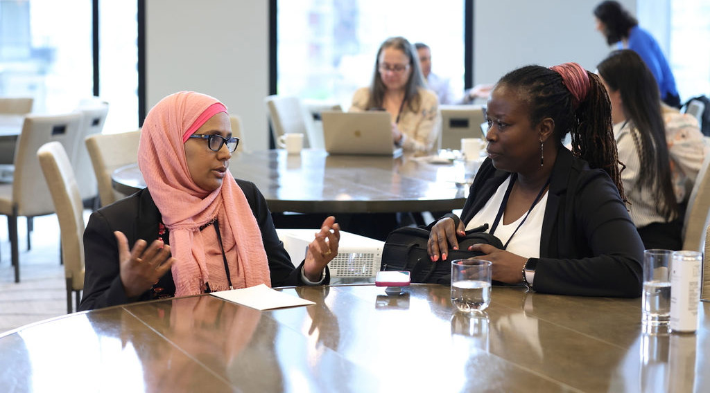 Two women have a discussion during a professional development course.