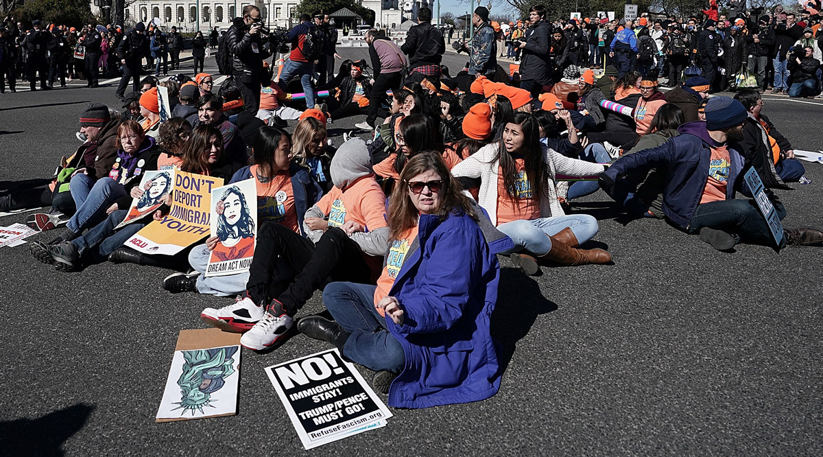 DACA Risking everything to become a doctor Protesters holding signs while sitting down at a rally in support of DREAMers
