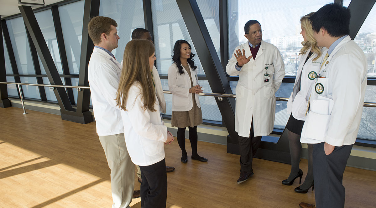 Selwyn Vickers, MD, senior vice president of medicine and dean of the University of Alabama School of Medicine, talks with students before the pandemic