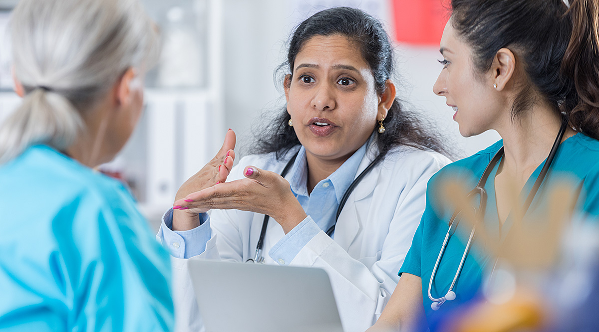 A group of doctors and medical professionals discussing a topic in a meeting