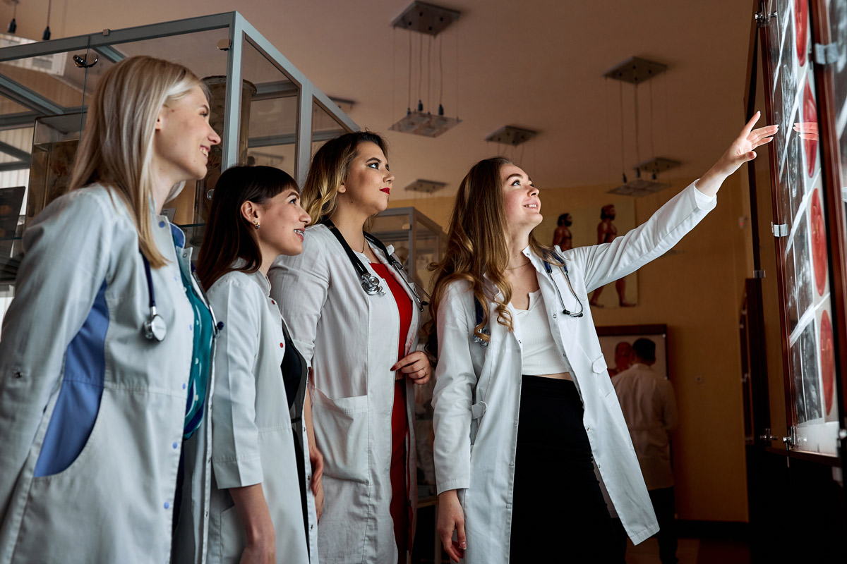 a group of young medical students examining medical images on a wall.