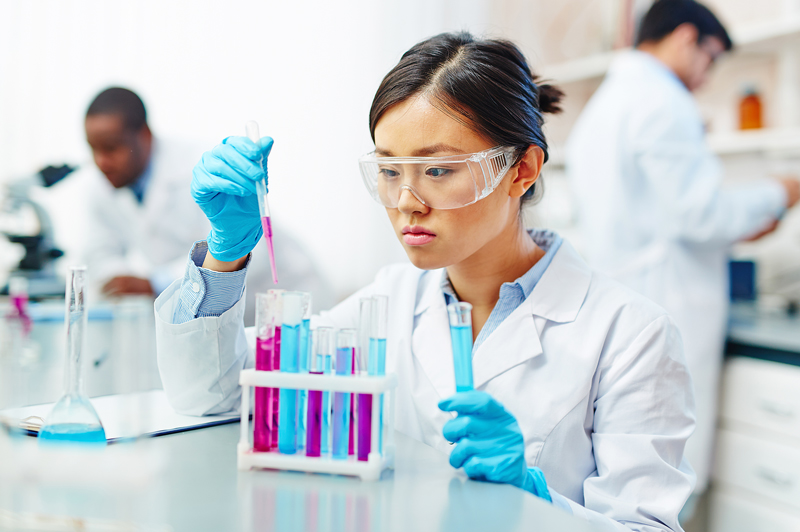 Researcher making experiment with liquid substances in flasks.