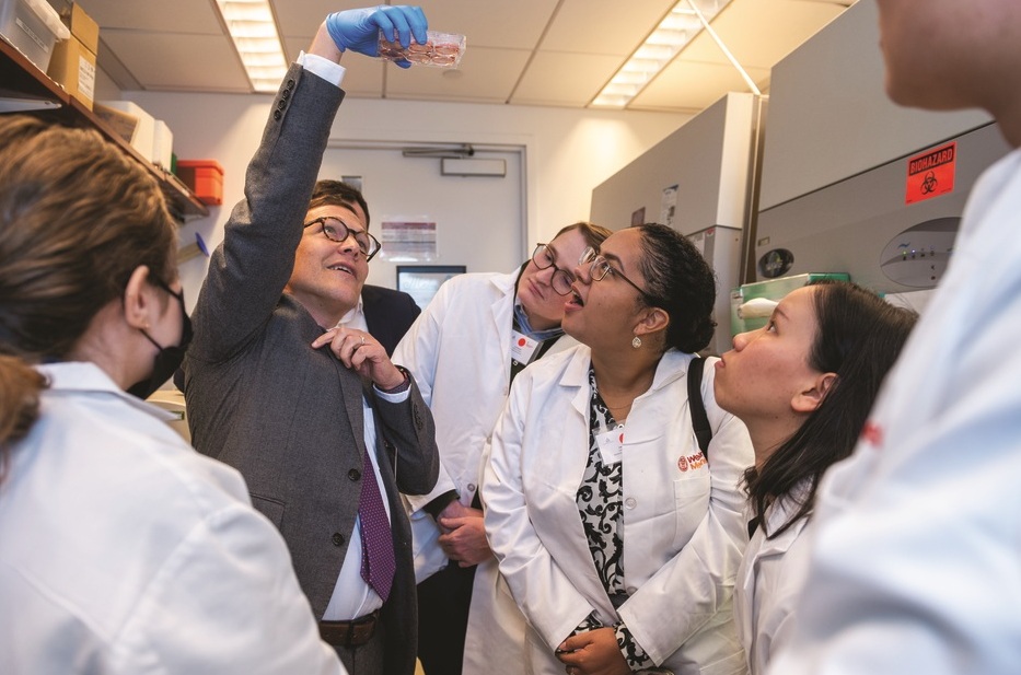 Medical students look up to examine a specimen.