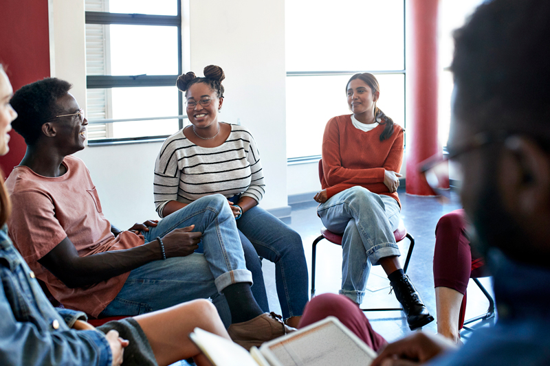 Smiling young students sitting with instructor