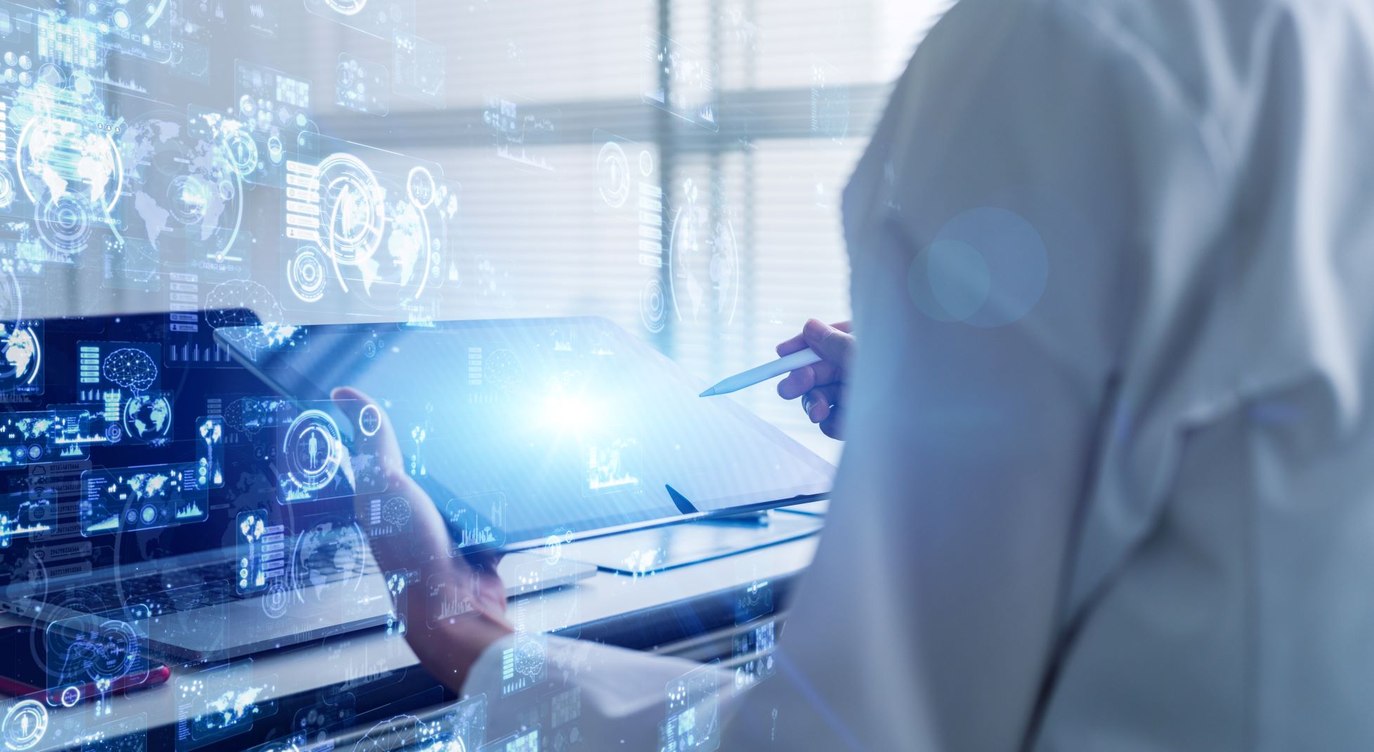 Medical professional holding tablet while looking at data charts and graphs
