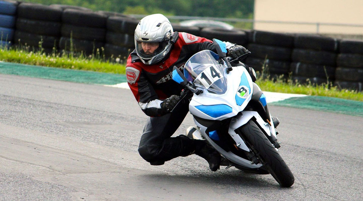 Travis Rieder, PhD, rides his motorcycle at a racetrack in 2014. A year later, he suffered a devastating crash and dependence on opioids.