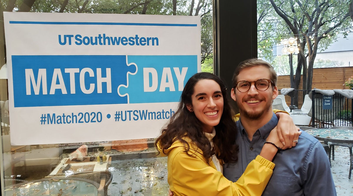 Christy Henderson, MD, and her husband pose in front of a banner provided by the University of Texas Southwestern Medical School for this year's virtual Match Day