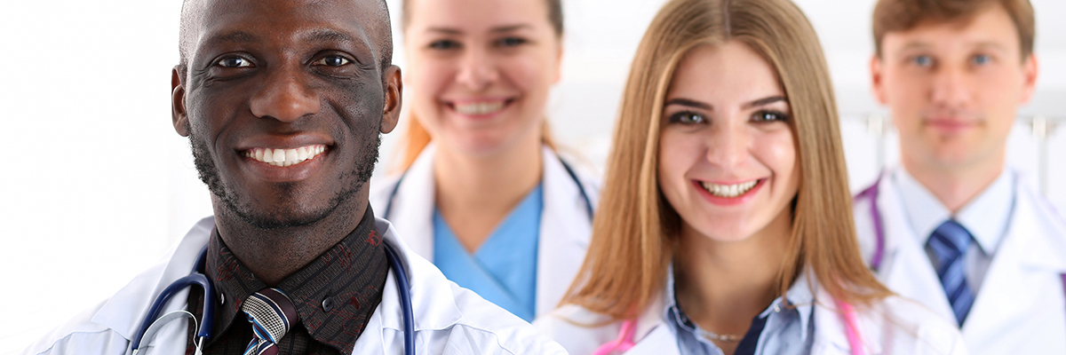 A close-up of 4 doctors smiling 