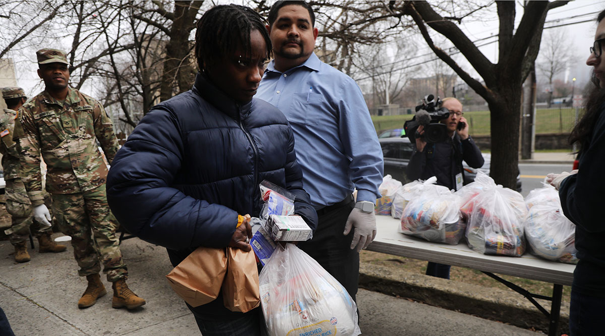 Residents receive food from the National Guard near a containment area set up to halt the spread of COVID-19 in New Rochelle, New York. 