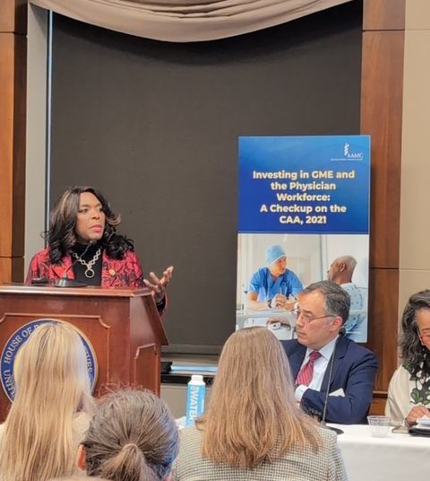 Woman standing at podium presenting during a conference