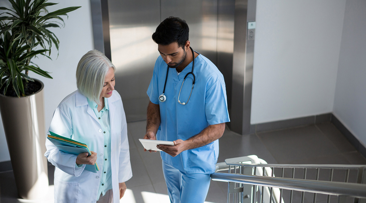 StandPoint Surveys Faculty A female doctor talks to a male medical student.