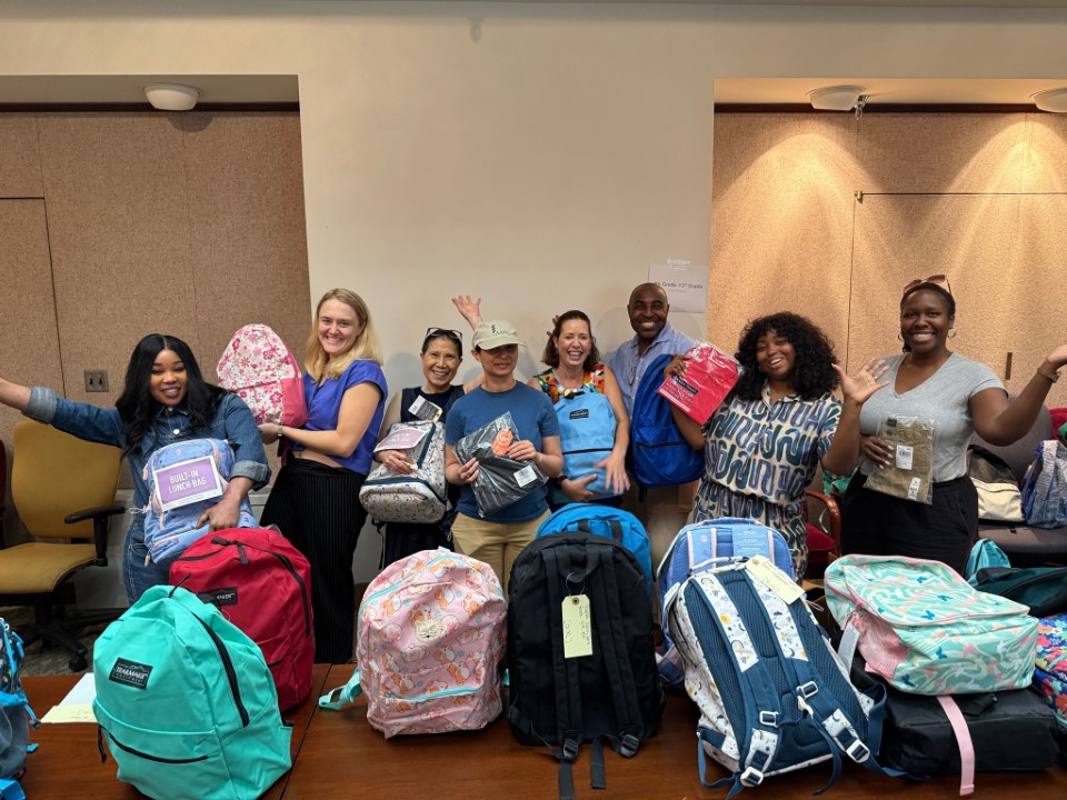 AAMC volunteers spend an afternoon packing and sorting 100-plus book bags for House of Ruth children, providing supplies and clothing for the school year.