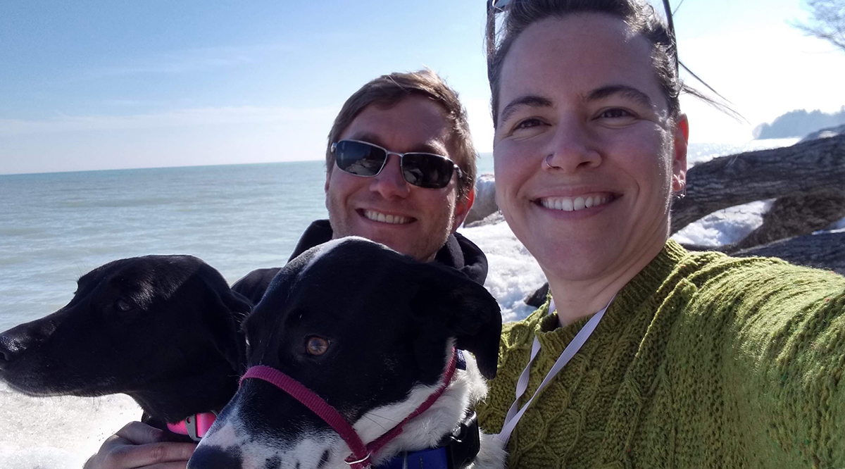 Aaron Zeleske and his partner hiking on the shore of Lake Michigan.