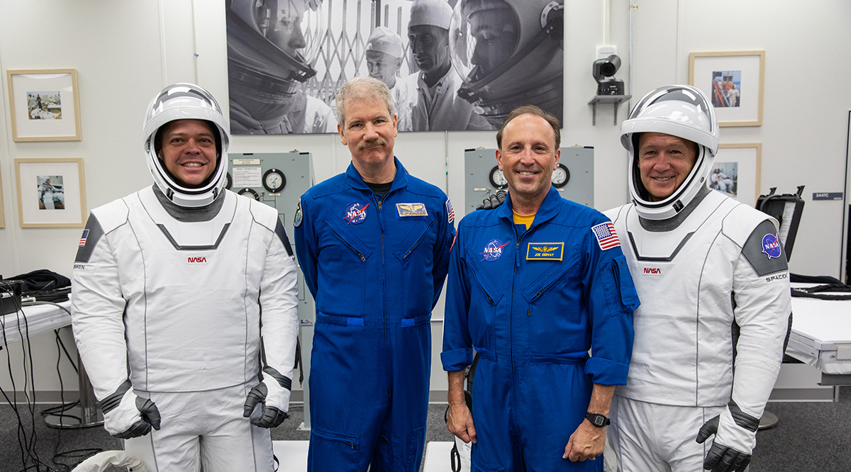 Astronauts Bob Behnken and Doug Hurley pose for a photo at Kennedy Space Center in Cape Canaveral, Florida, prior to the NASA/SpaceX launch of the first Commercial Crew Program mission on May 30, 2020. Posing in blue flight suits are NASA flight surgeons Joe Dervay, MD, right, and Steve Hart, MD, left.