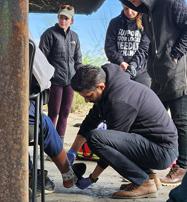 Street Med STL volunteers wrap a patient’s foot.