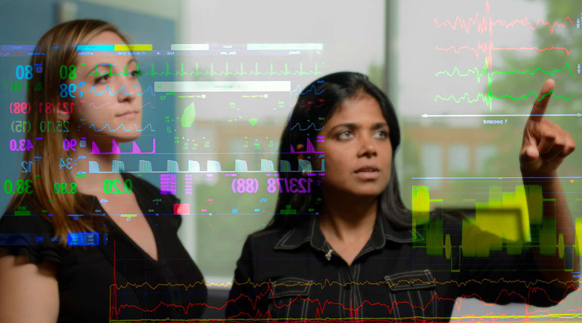 Suchi Saria, PhD, director of the Machine Learning, AI and Healthcare Lab at Johns Hopkins (right), studies patient data produced by an artificial intelligence system that quickly detects sepsis.