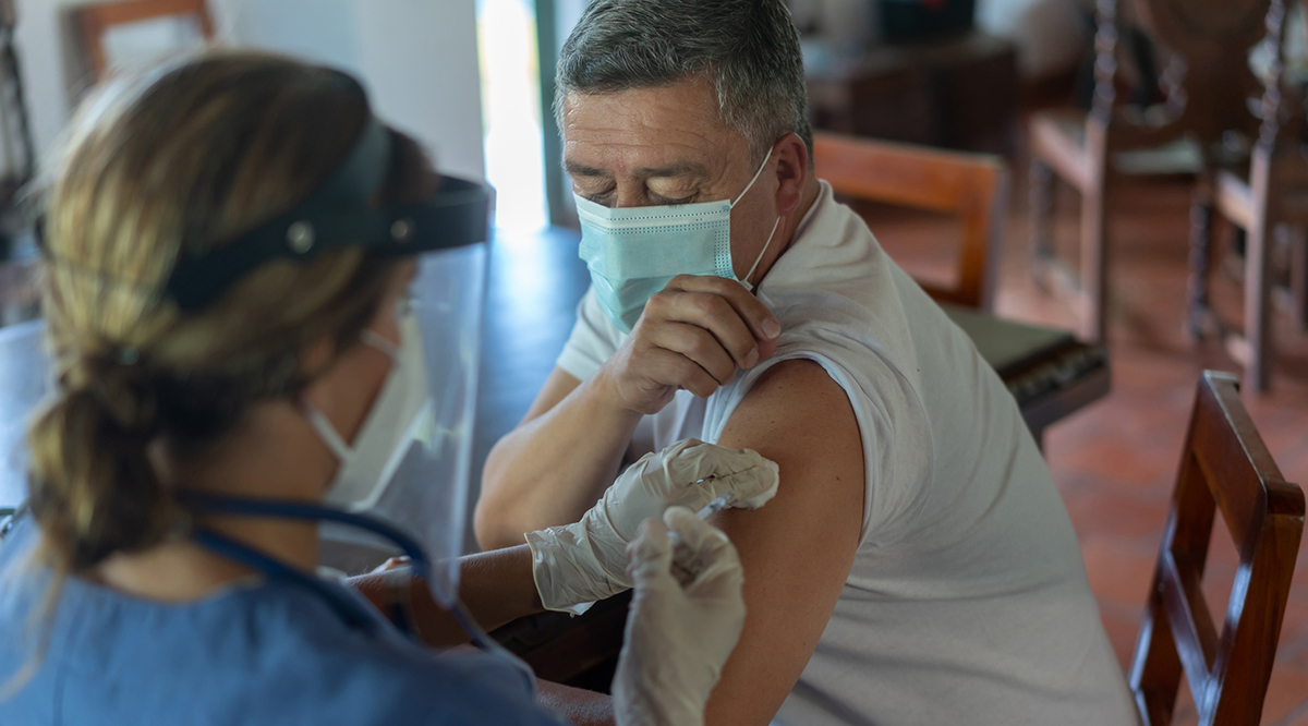 Adult man getting a COVID-19 vaccine at his rural house