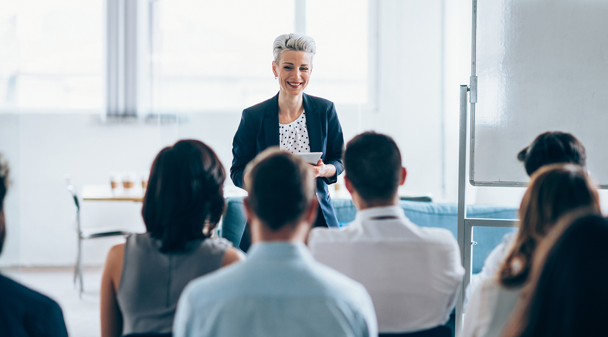A female presenter speaking during a business seminar