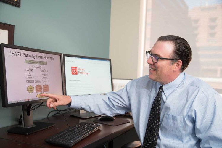 Simon Mahler shows the HEART Pathway clinical protocol on a computer screen.