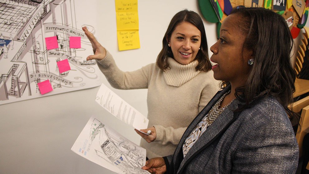 At a meeting on how to address economic inequities, Darlene Hightower (right), Rush University Medical Center’s associate vice president for community engagement, speaks with Lisa Weichman, head of a Chicago nonprofit. Credit: Rush Production Group Darlene Hightower and Lisa Weichman meeting on how to address economic inequities