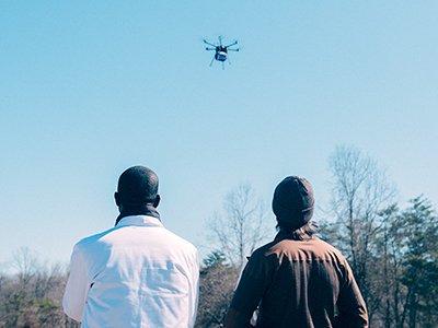 Dr. Timothy Amukele (left) and drone engineer Jeff Street from Johns Hopkins Medicine watch the drone take flight for their experiment.