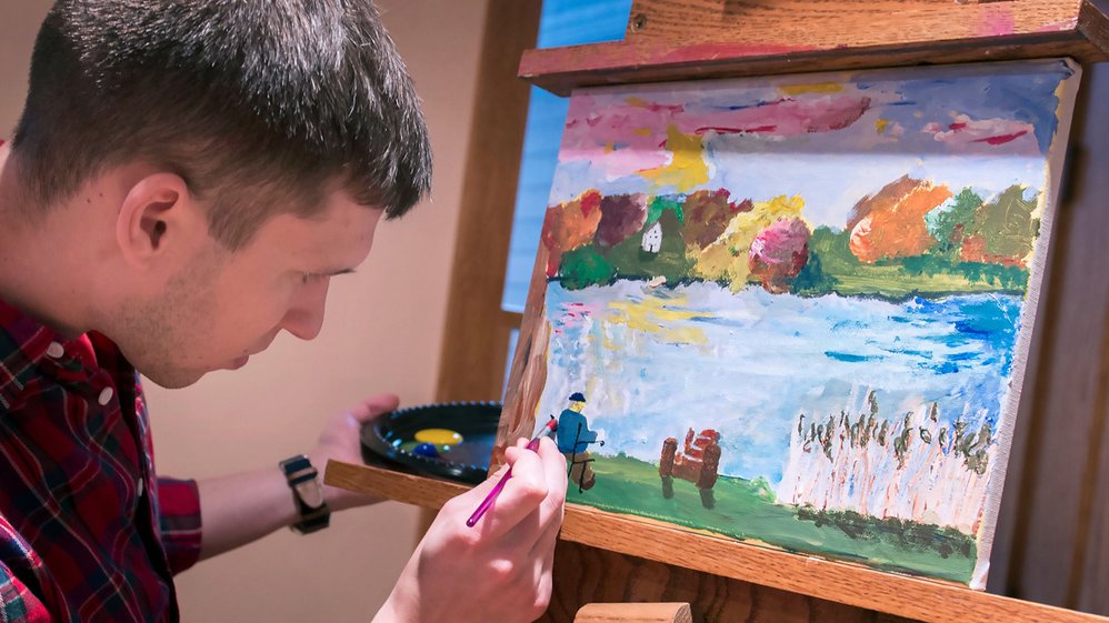 Penn State College of Medicine student Scott Paradise creates a copy of a Van Gogh painting based on a partner’s description. The class emphasizes the importance of open-ended communication in medicine.