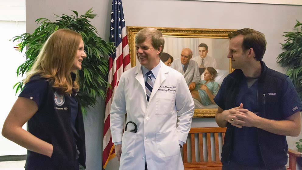 Amy Prescott, MD, John Prescott, MD, and Jacob Isserman, MD, chat on Georgetown University School of Medicine’s campus.