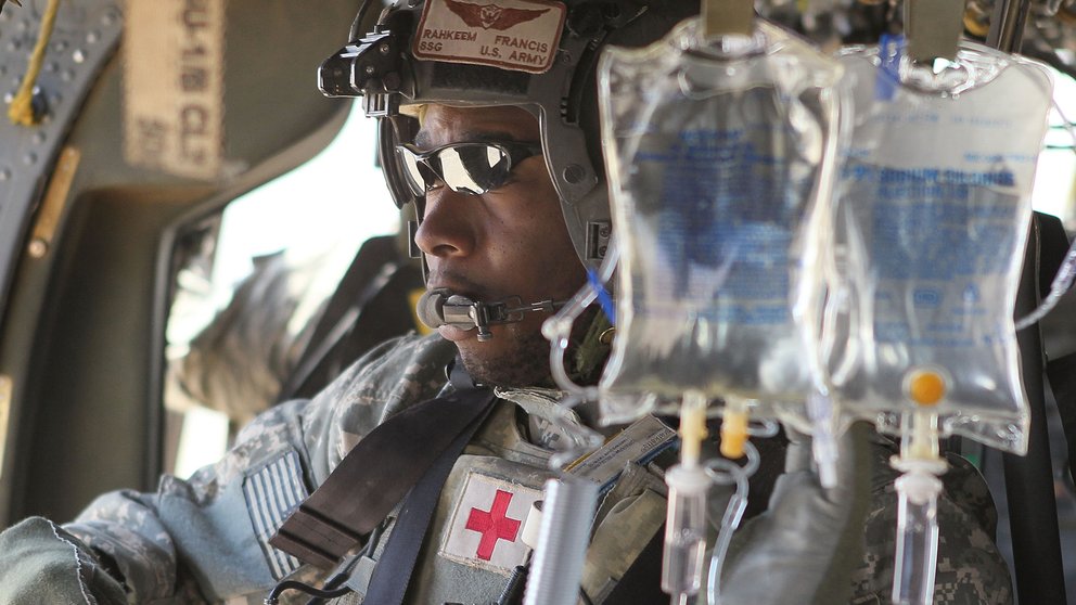 U.S. Army flight medic SSG Rahkeem Francis prepares to receive wounded Marines aboard his MEDEVAC helicopter