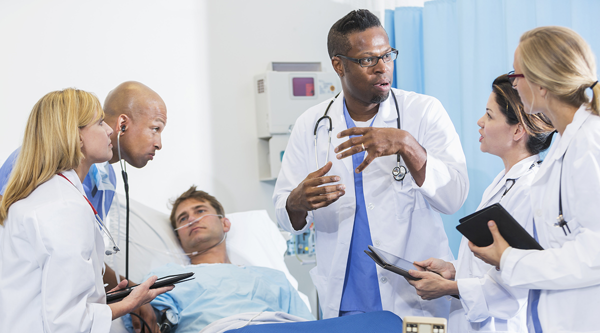 Doctor giving instructions to medical students while seeing a patient