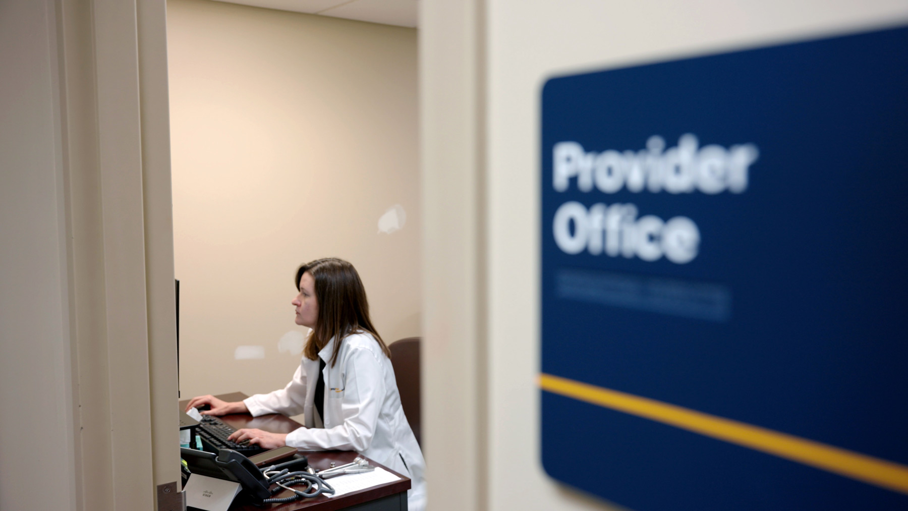 Dr. Melanie Ward sits in her office at a desk and computer workstation