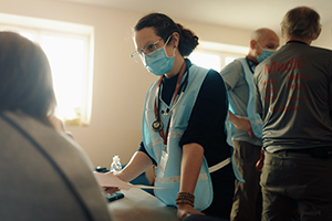 Erica Nelson, MD, consults with a patient at an internally displaced persons site in Western Ukraine.