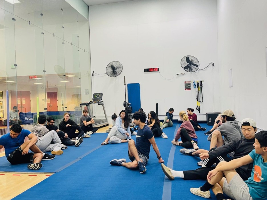 students stretching in glass sitting on mat