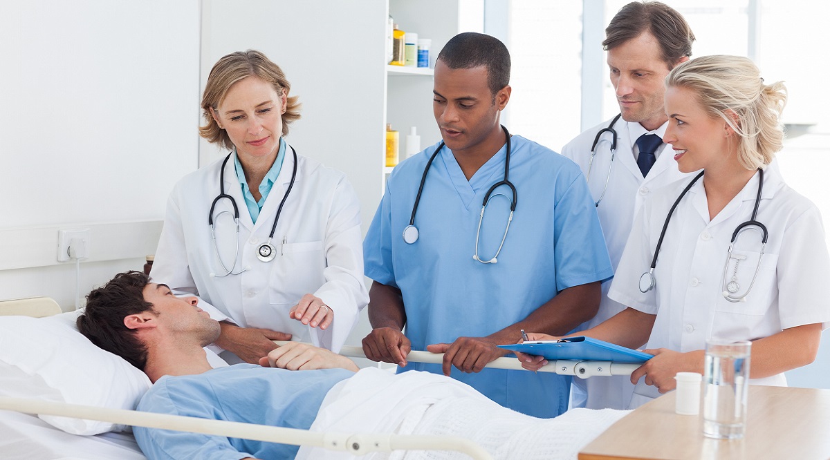 Serious medical team around the bed of a patient