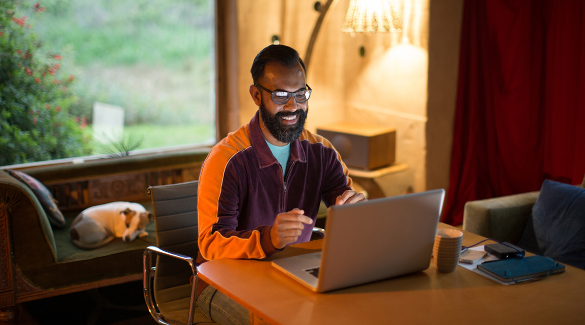 A person sits at a table with a laptop
