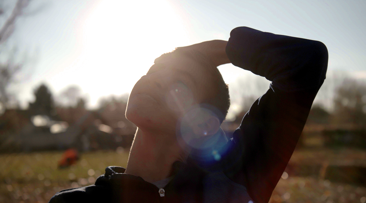 A person stretching their neck outdoors