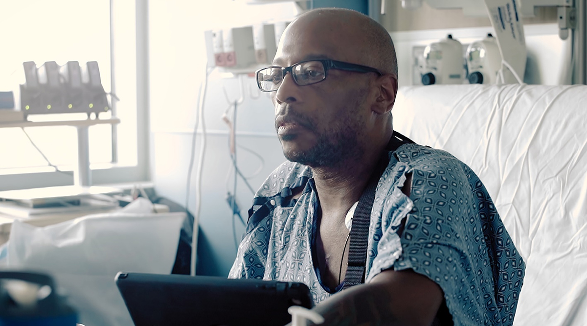 A male patient sitting on a hospital bed