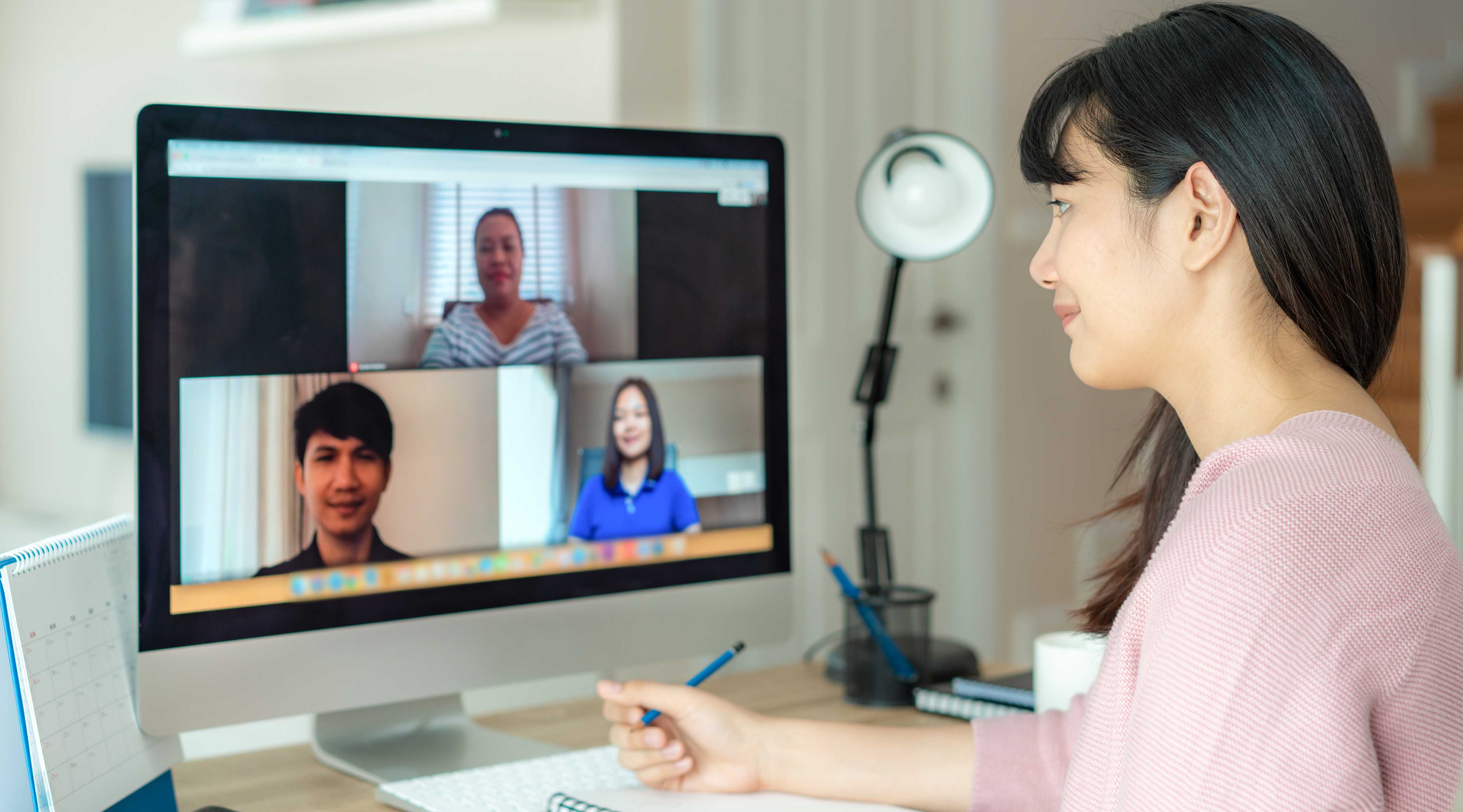 A woman leads a meeting over video chat. 