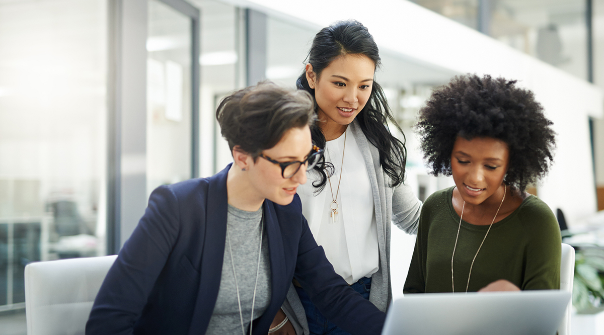 A group of businesswomen using a laptop during a meeting at work