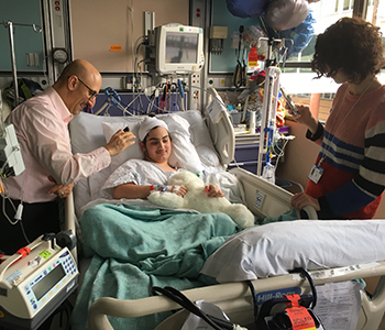 A patient in the UCSF pediatric intensive care unit plays with Paro, a robotic pet seal.