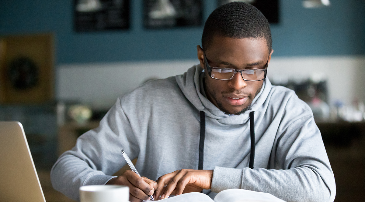 Student studying with books and laptop