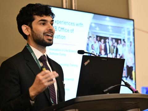 Man speaking at podium with presentation behind him