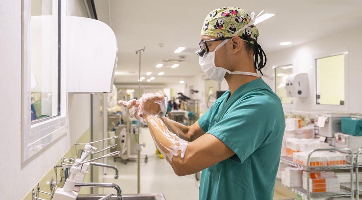 Surgeon wearing mask washing hands in hospital