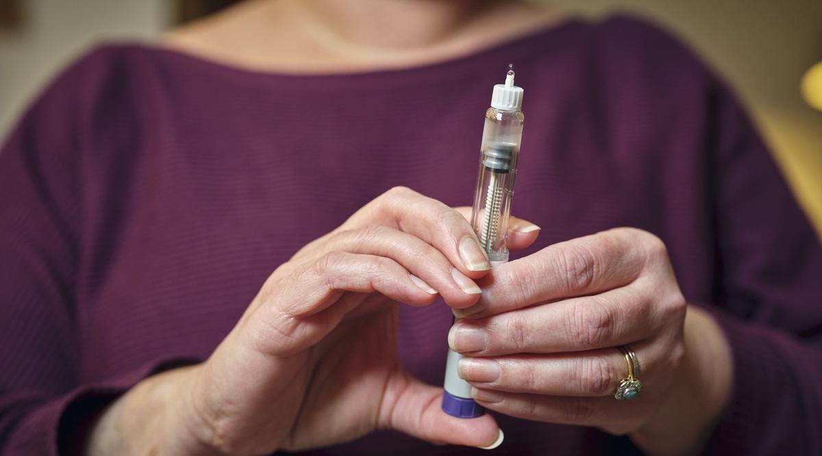 A woman prepares for a subcutaneous self-injection with a semaglutide pen 'diet drug' . The modern wonder weight loss drug and diabetes treatment highlights a personal healthcare routine at home.