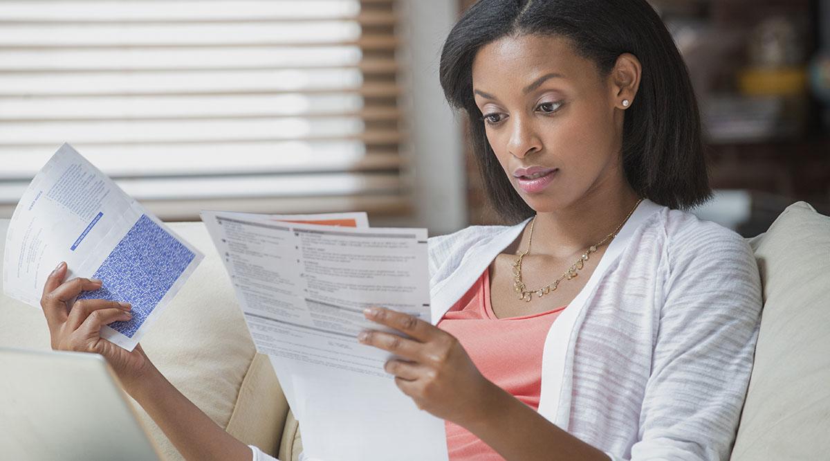 A woman stares at a handful of bills