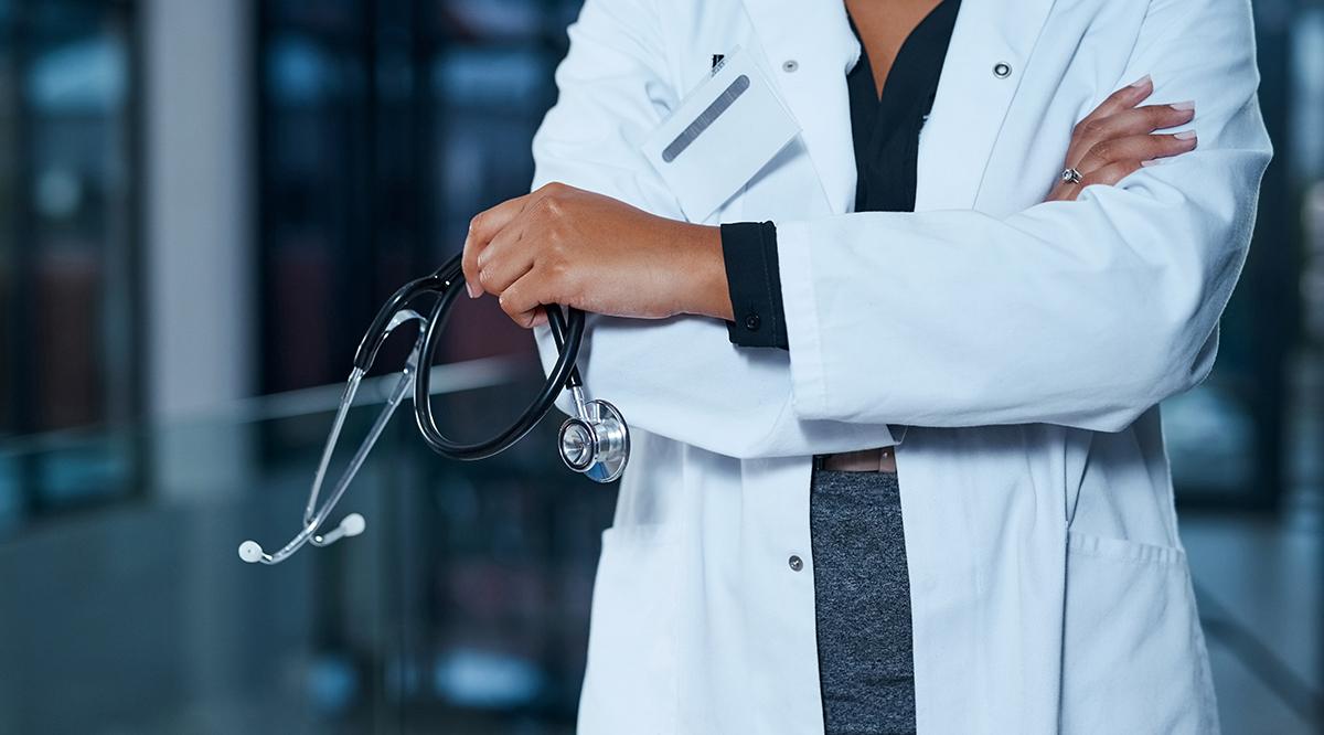 Doctor in a lab coat holding a stethoscope 