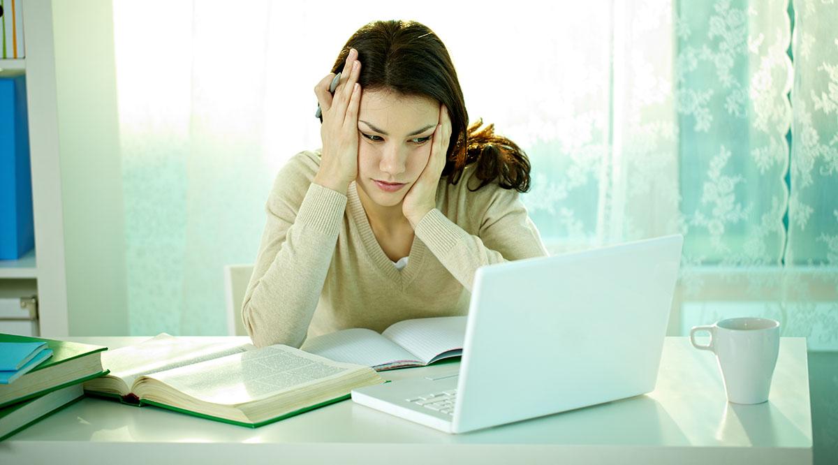 A stressed student looks at her computer